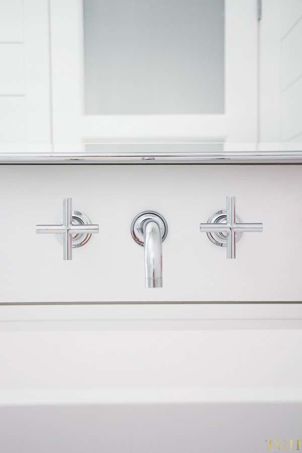 White modern bathroom makeover with a wall mounted faucet, trough sink and shiplap