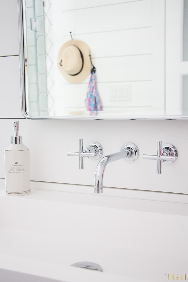 Modern farmhouse bathroom makeover featuring a wall mounted faucet, trough sink, and shiplap