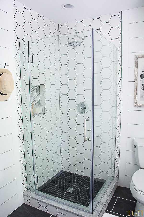 White modern bathroom makeover featuring a shower with hexagon tile and shiplap