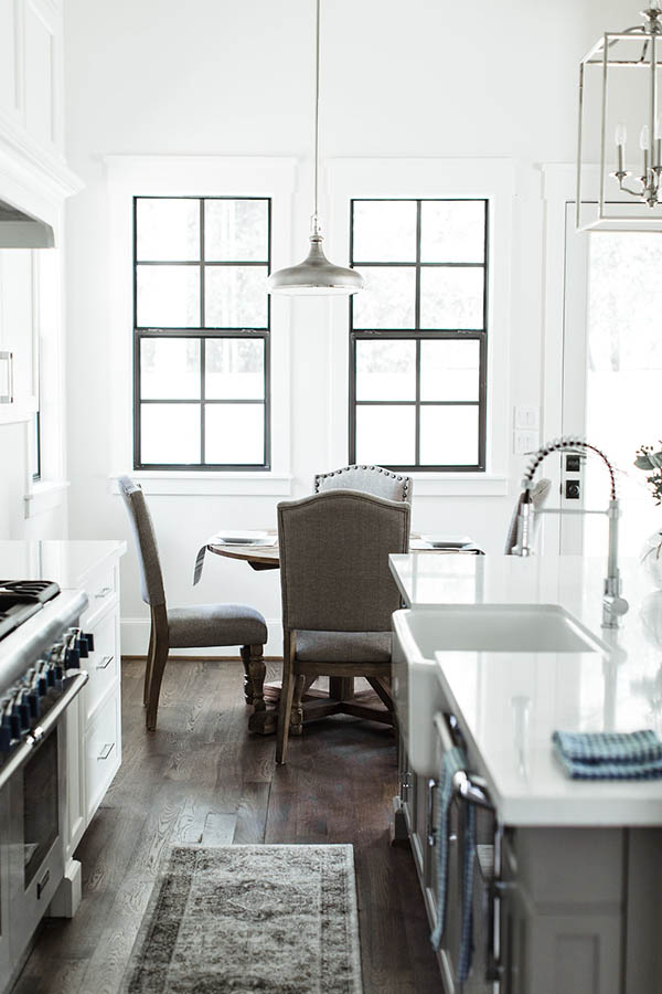 Black trim windows kitchen. Breakfast nook table round. Modern farmhouse kitchen black and white.